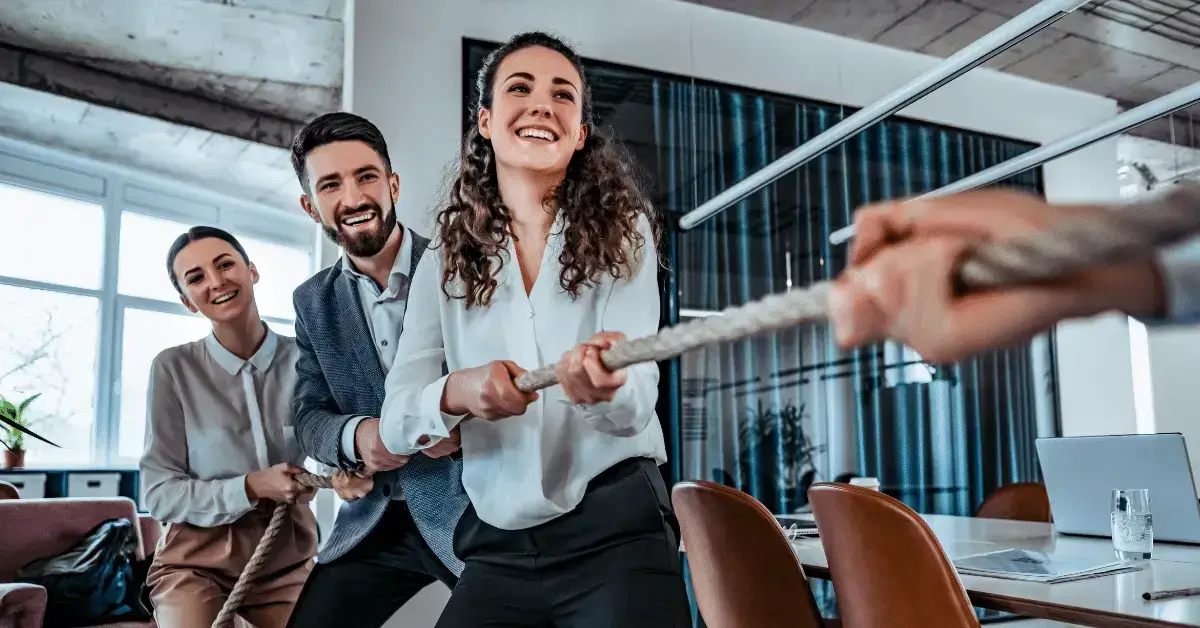 Coworkers in an office playing tug of war